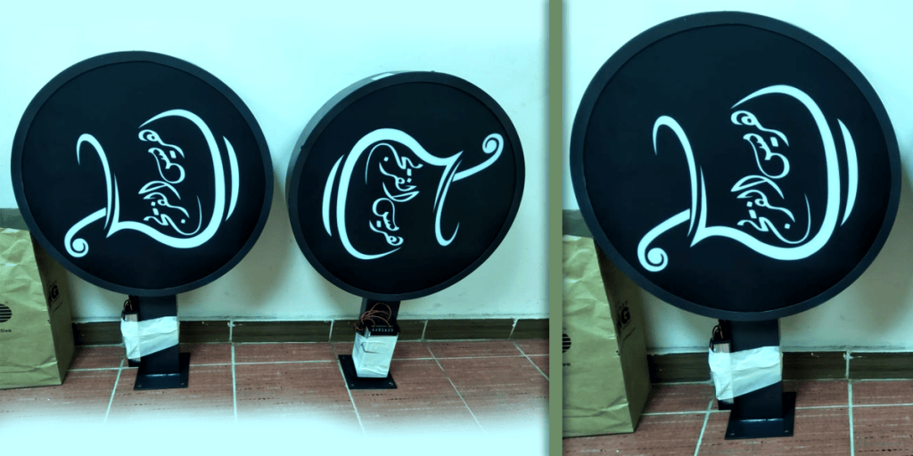 aRound black LED lightbox signs with illuminated Arabic calligraphy, manufactured in Musaffah, Abu Dhabi by Point to Point Advertising Designs